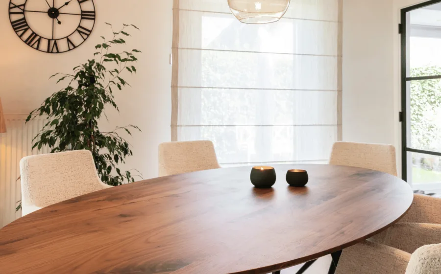 Ovale eettafel en witte vouwgordijnen