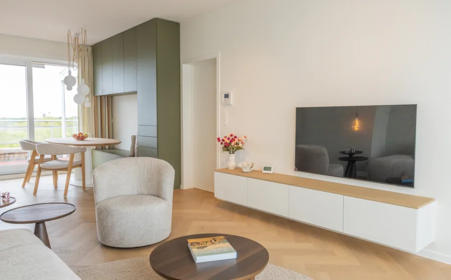 Woonkamer met multifunctionele, lichtgroene kast op maat met zitbank.