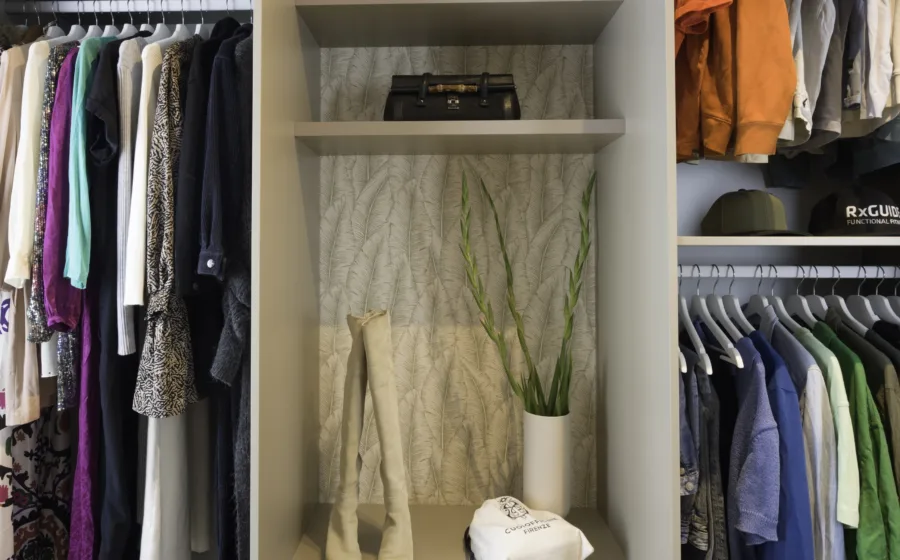 Detail inloopkast op maat met open achterkant en behangpapier als subtiel accent