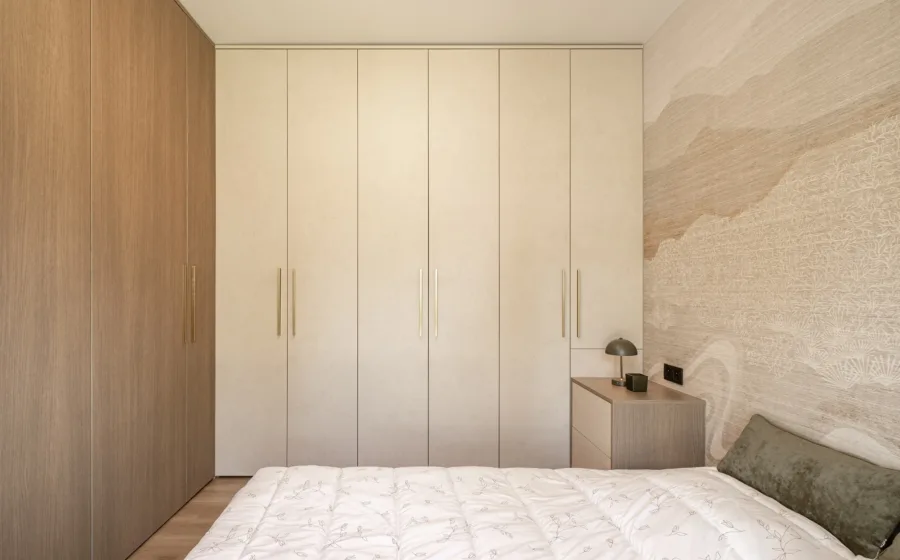 Slaapkamer met kamerhoge kledingkasten tot aan het plafond, per muur een andere tint.