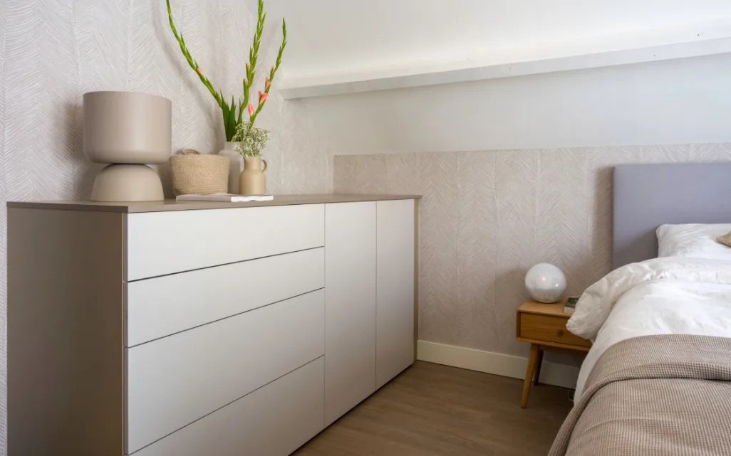 Slaapkamer met kast op maat in de kleur Nature Grey, tweepersoonsbed, behangpapier met natuurlijke bladstructuur. | Aanhuis.be
