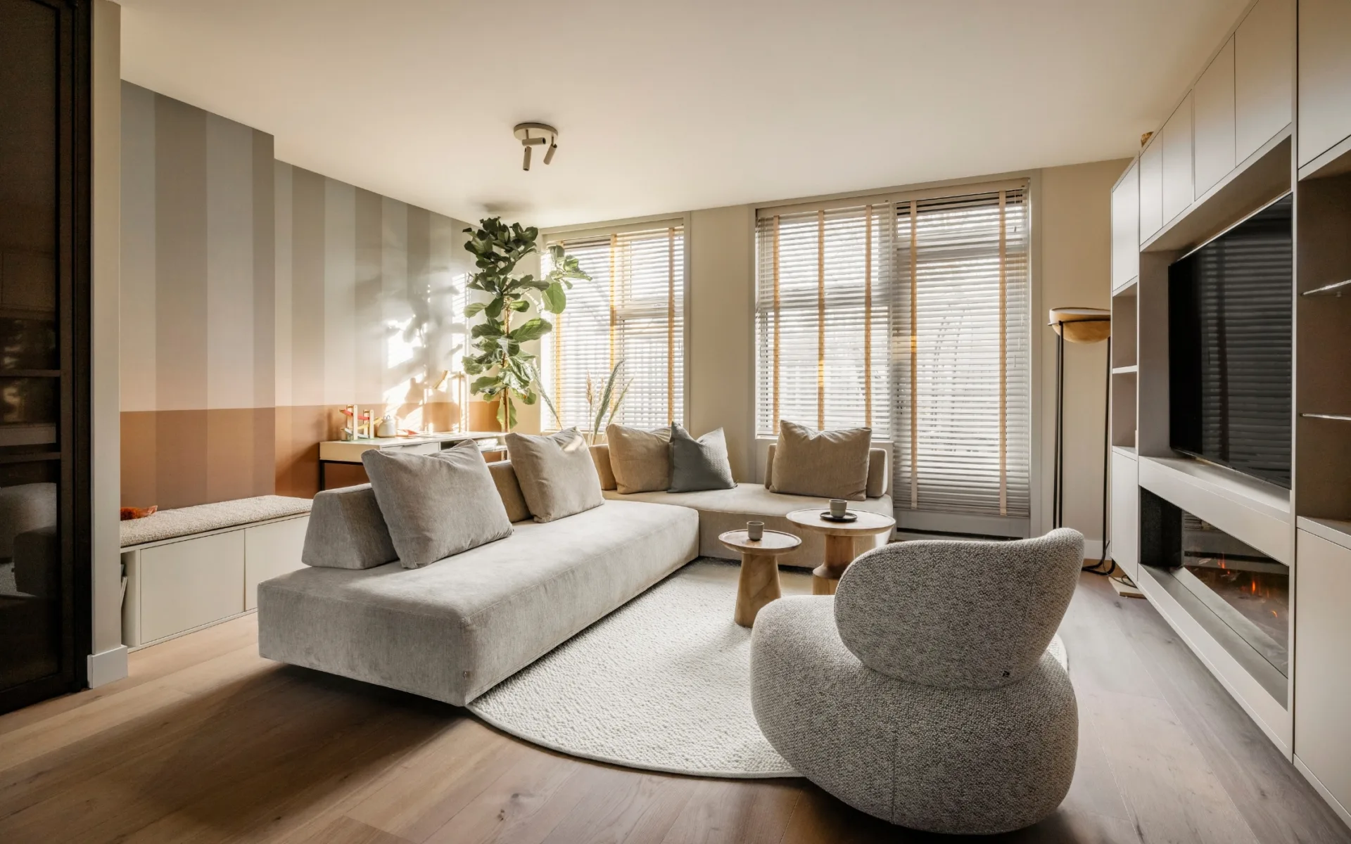 jaloezieën en een organische vloerkleed met een kast op maat in de woonkamer