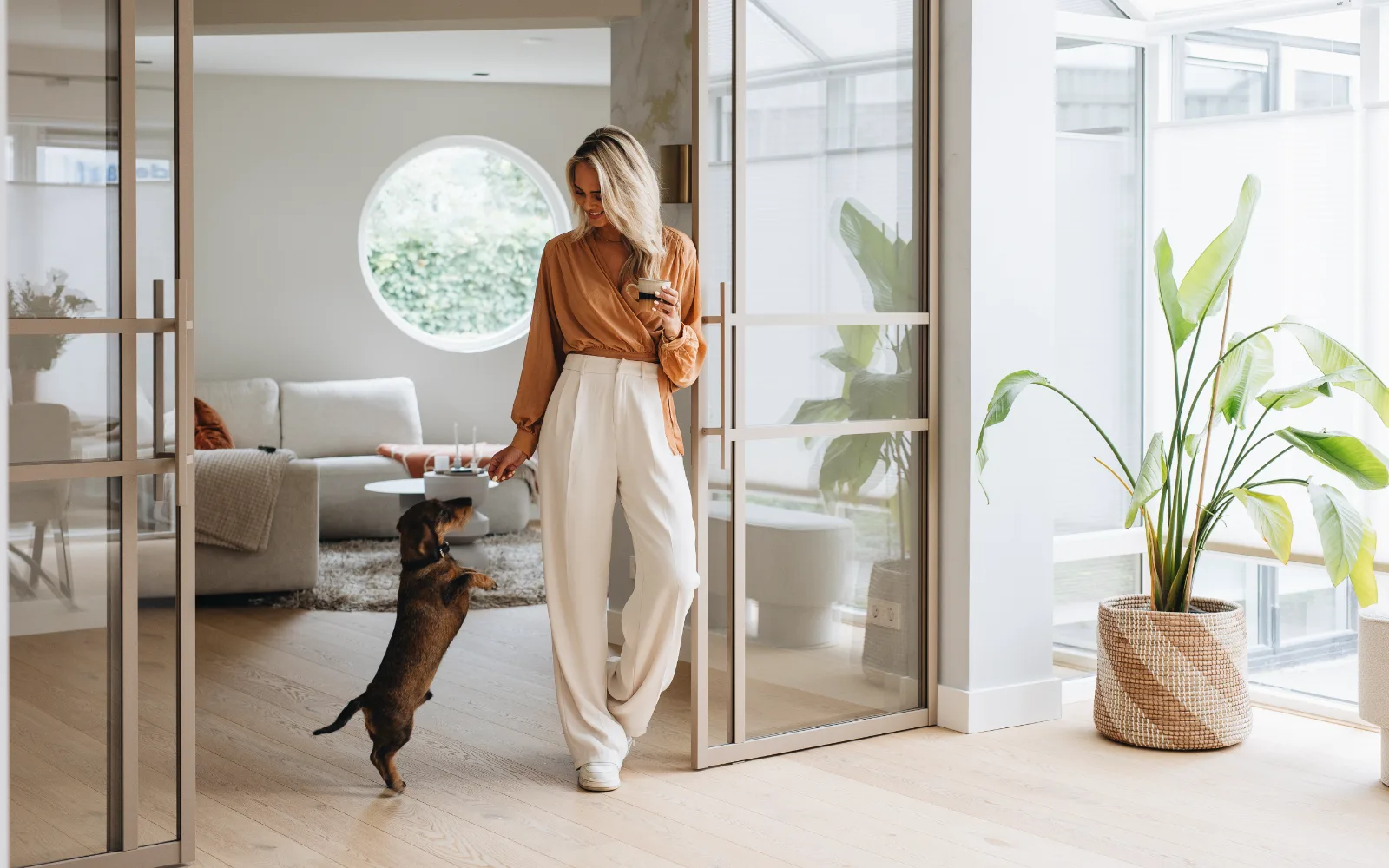 Beige stalen pui in de woonkamer met een houten Lindura vloer