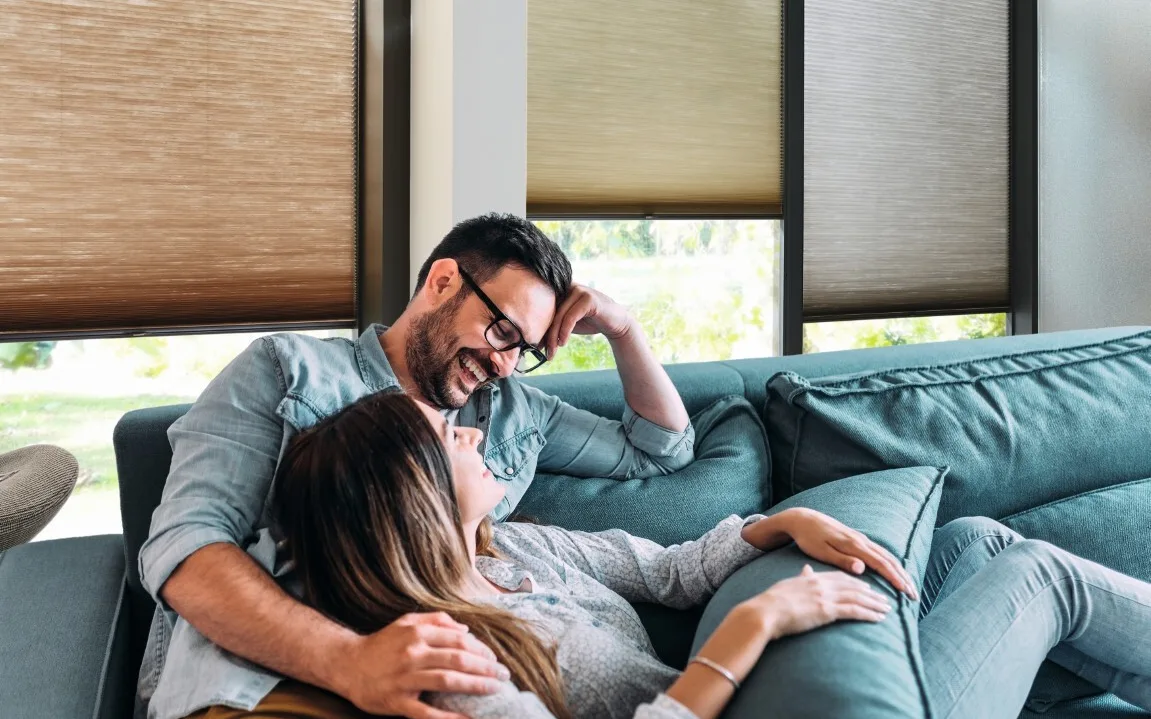 Blij mensen op de bank met elektrische raamdecoratie