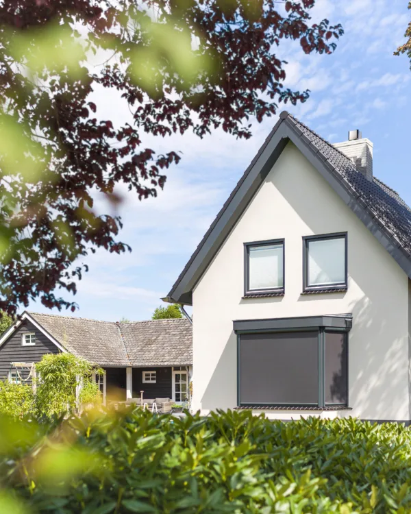 Wit huis met erker met grijze screens op maat
