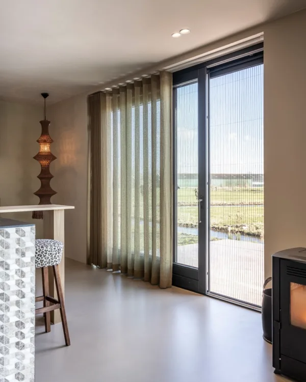 Schuifpui met stijlvolle plissé vliegenraam en wavegordijnen, passend bij het moderne interieur.