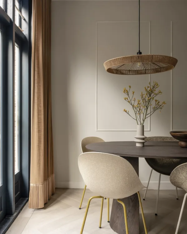 Art Nouveau zithoek met fluwelen gordijn, eettafel met stoelen in ronde, organische vormen en zachte natuurtinten.