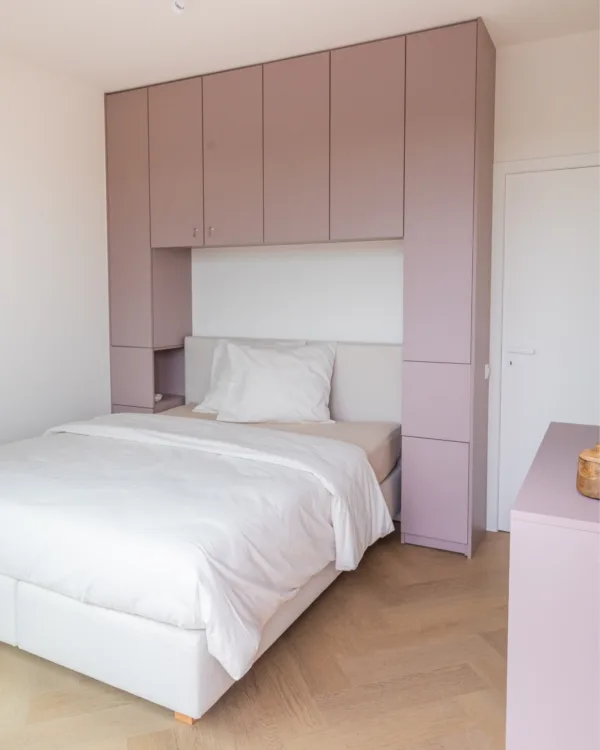 Roze kast op maat om bed gebouwd met licht eiken pvc visgraat vloer