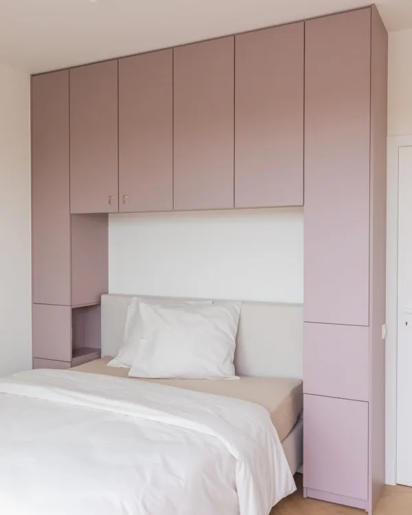 Slaapkamer met kamerhoge roze kast op maat voor extra opbergruimte. | Aanhuis.be