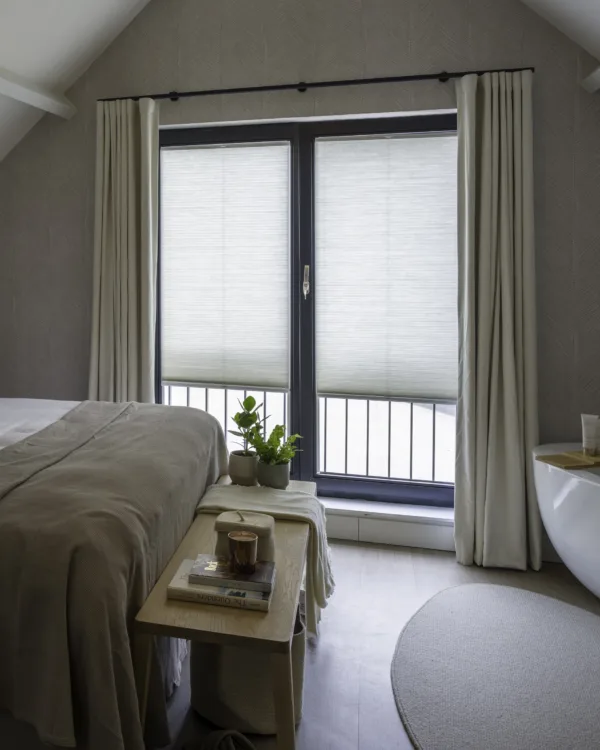 Slaapkamer met verduisterende overgordijnen en plisségordijnen