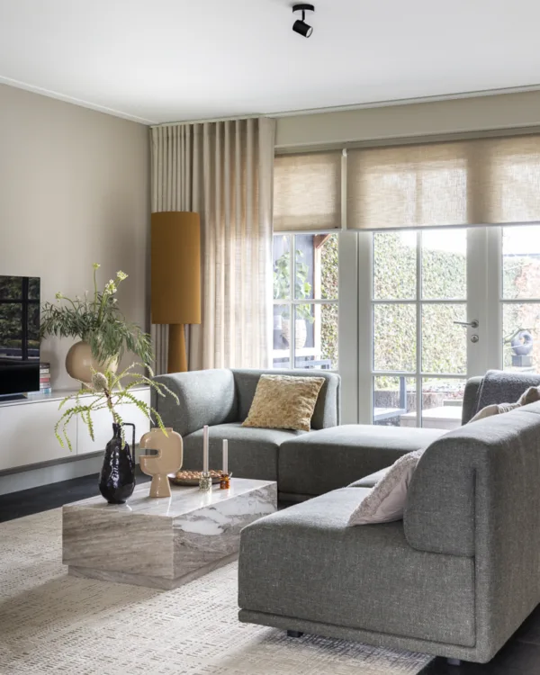 Woonkamer met lichte kleuren, wavegordijnen en rolgordijnen