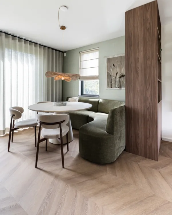Eetkamer met ronde tafel, stoelen en hoekbank, visgraat vinylvloer