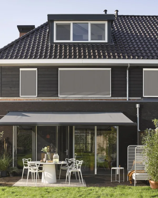 huis met buitenzonwering, screens en knikarmscherm
