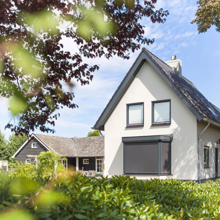 Wit huis met erker met grijze screens op maat