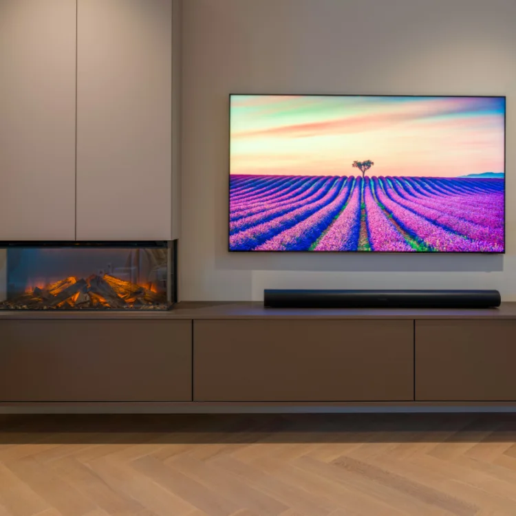 Tv kast in taupé en bruin, met elektrische haard, visgraatvloer en lichtgrijze muren. | Aanhuis.be