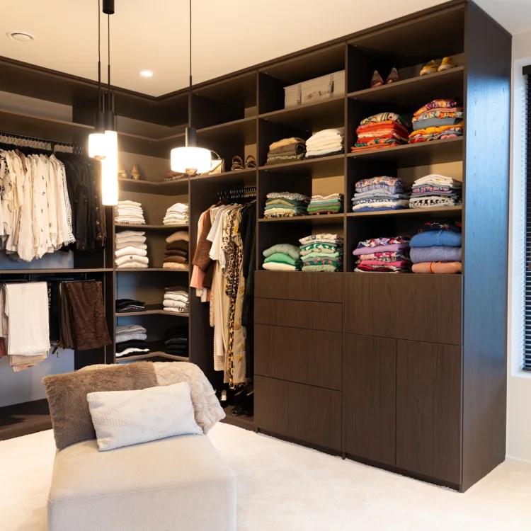 Ruime inloop kledingkast op maat in donkerbruin met draaideuren en open vakken