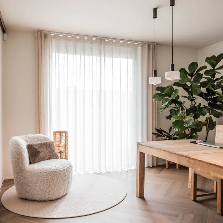 Visgraatvloer met een rond vloerkleed en witte gordijn